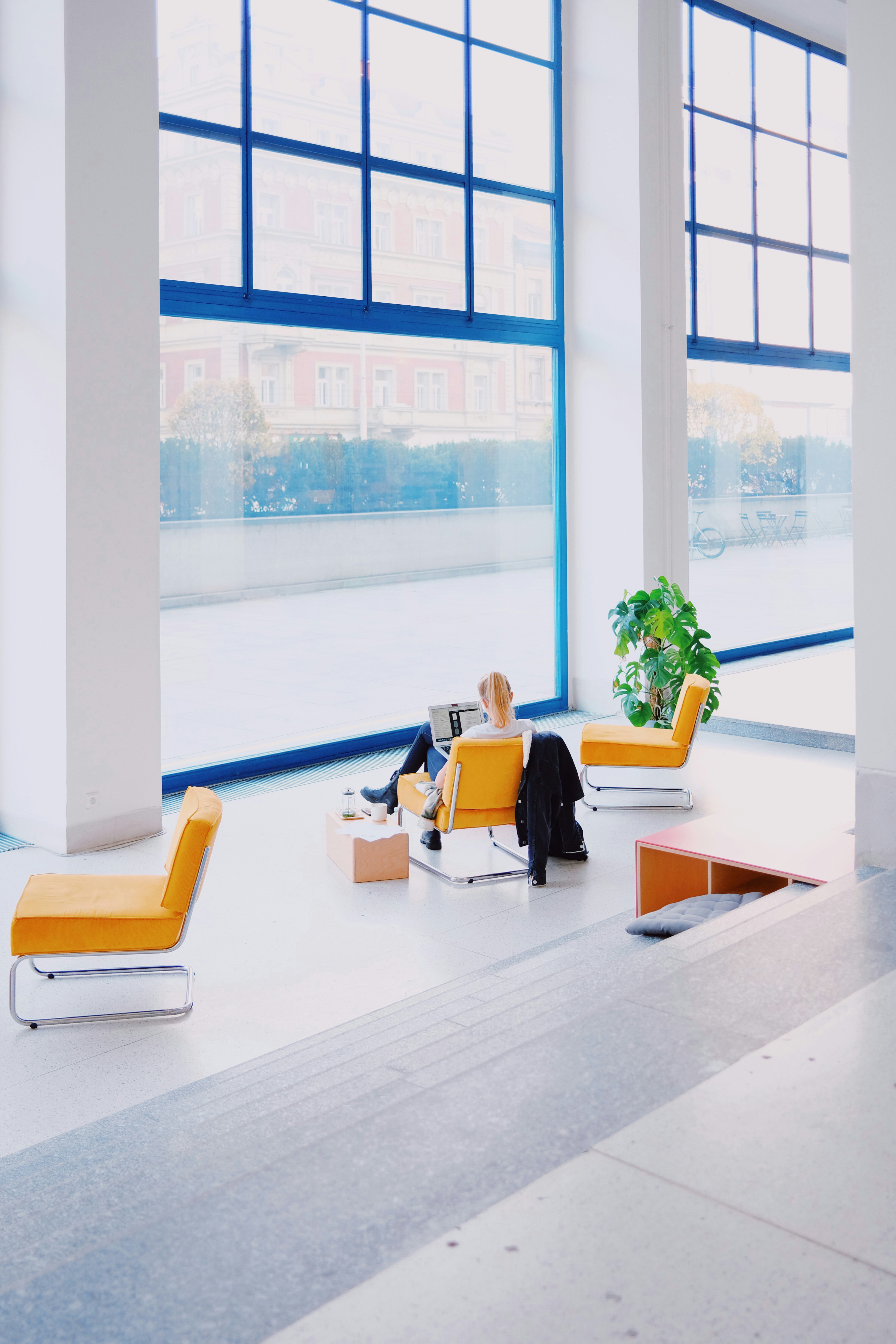 Eine Frau arbeitet am Laptop im Foyer eines Büros.